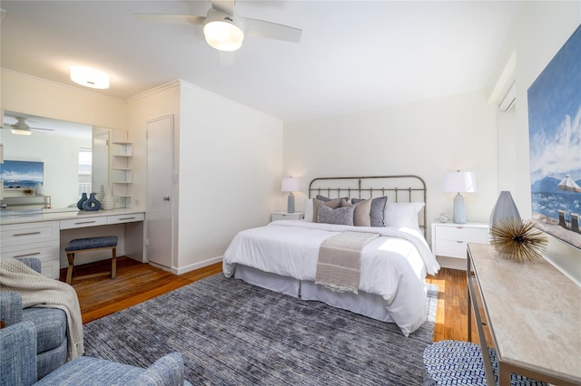 bedroom featuring wood finished floors, ornamental molding, a ceiling fan, and baseboards