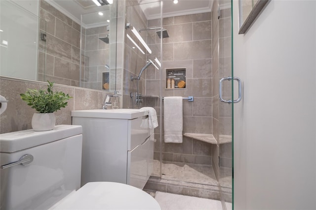 bathroom with tile walls, crown molding, toilet, a stall shower, and vanity
