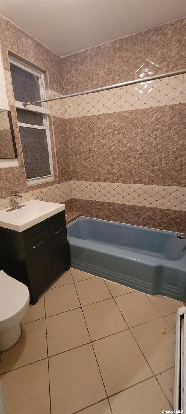 bathroom with toilet, tile walls, vanity, tile patterned floors, and decorative backsplash