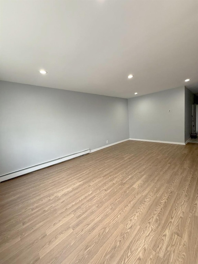 basement with baseboard heating, light wood finished floors, baseboards, and recessed lighting