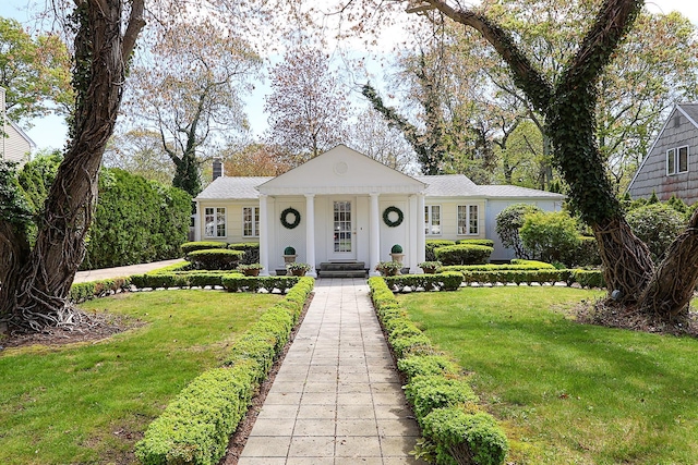 45 Holiday Blvd, Center Moriches, NY 11934 - neoclassical home with a front yard and a chimney