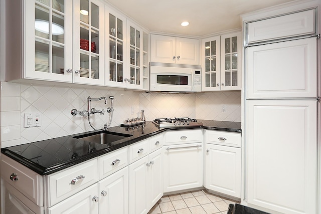 45 Holiday Blvd, Center Moriches, NY 11934 - kitchen featuring white microwave, a sink, stainless steel gas cooktop, glass insert cabinets, and light tile patterned flooring