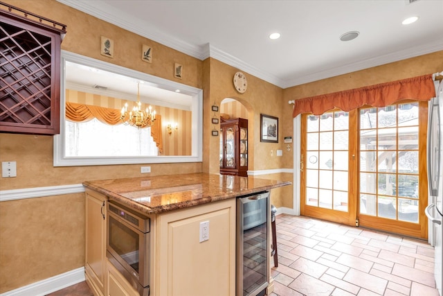 kitchen featuring wine cooler, stainless steel microwave, arched walkways, light stone counters, and a chandelier