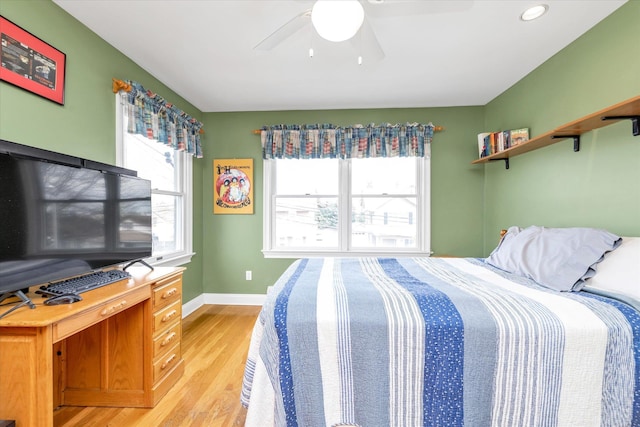 bedroom featuring light wood finished floors, baseboards, and a ceiling fan