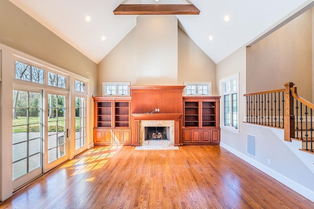 11 Victorian Ln, Brookville, NY 11545 - unfurnished living room with high vaulted ceiling, stairway, light wood-style flooring, a high end fireplace, and plenty of natural light