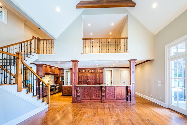 11 Victorian Ln, Brookville, NY 11545 - kitchen featuring decorative columns, high vaulted ceiling, light wood finished floors, a spacious island, and recessed lighting