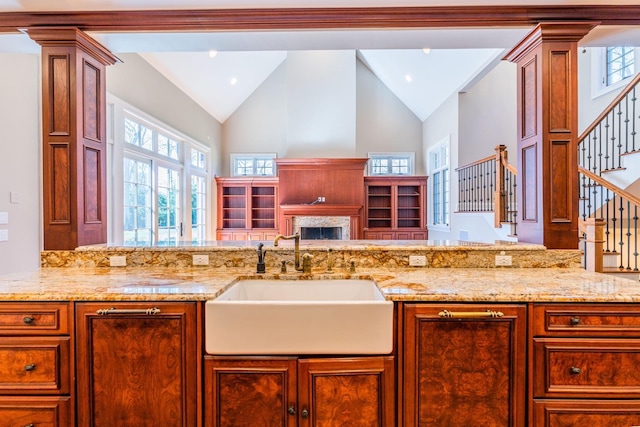 11 Victorian Ln, Brookville, NY 11545 - kitchen featuring high vaulted ceiling, light stone counters, open floor plan, and brown cabinets