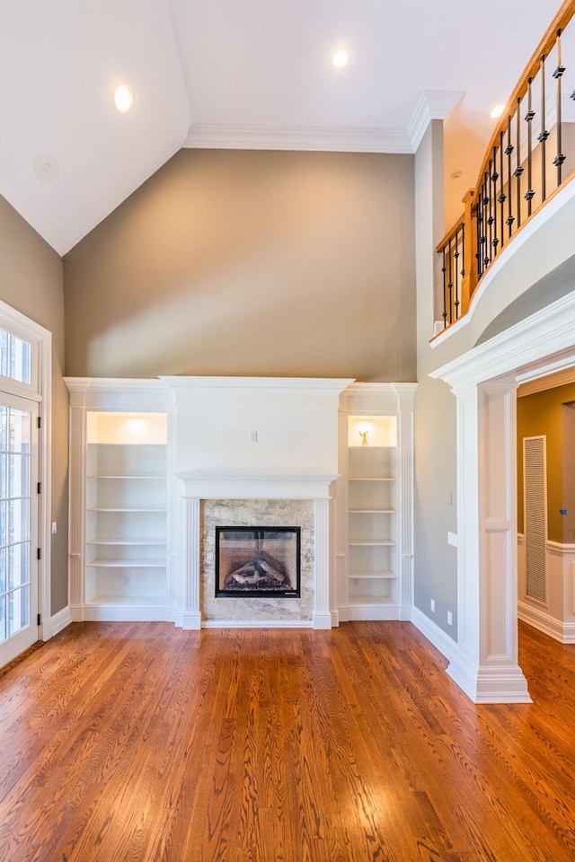 11 Victorian Ln, Brookville, NY 11545 - unfurnished living room featuring high vaulted ceiling, a fireplace, wood finished floors, built in features, and ornamental molding