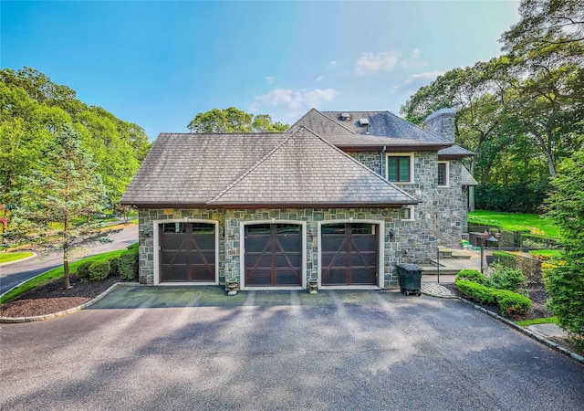 11 Victorian Ln, Brookville, NY 11545 - view of home's exterior featuring stone siding, a chimney, and driveway