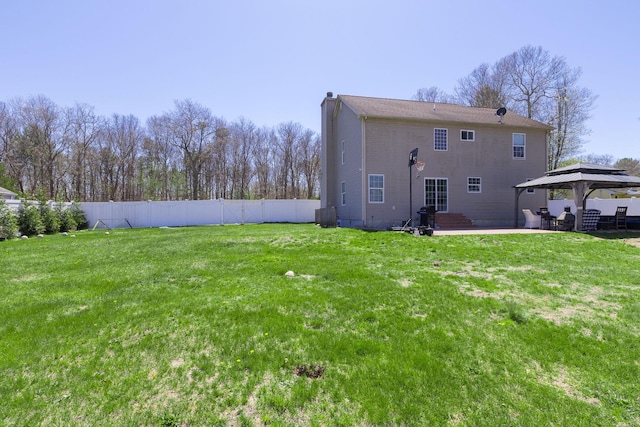 back of house with a gazebo, a lawn, a chimney, and fence