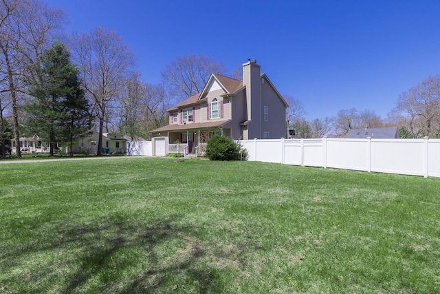 view of yard featuring fence and a garage