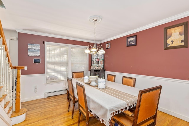 dining room with light wood-style floors, wainscoting, a baseboard radiator, stairs, and a notable chandelier