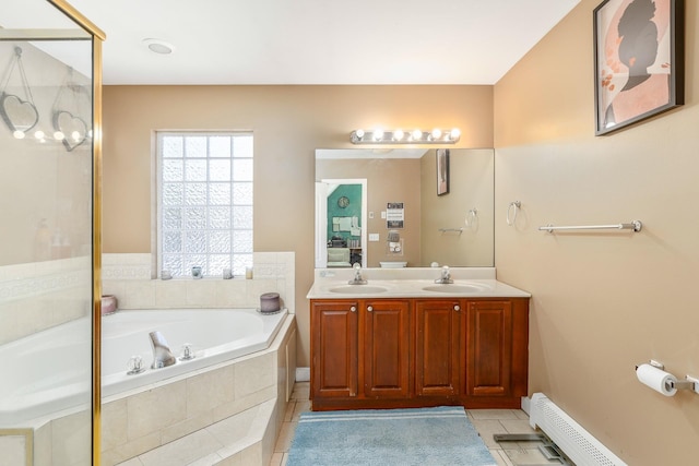 bathroom with a baseboard heating unit, tile patterned floors, a bath, and a sink