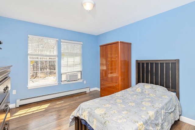 bedroom featuring baseboards, wood finished floors, and baseboard heating