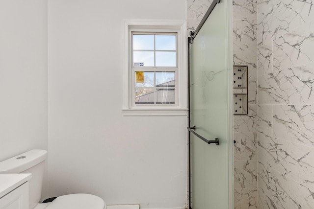 bathroom featuring toilet, vanity, and a stall shower