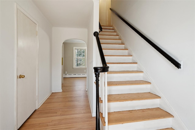 950 Main Bayview Rd, Southold, NY 11971 - stairs featuring arched walkways, a baseboard heating unit, and wood finished floors