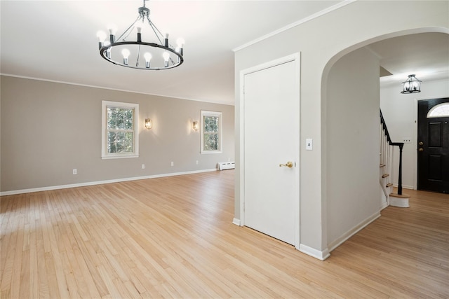 950 Main Bayview Rd, Southold, NY 11971 - empty room featuring arched walkways, light wood-type flooring, an inviting chandelier, and crown molding