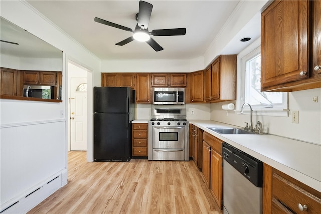950 Main Bayview Rd, Southold, NY 11971 - kitchen featuring a sink, brown cabinetry, baseboard heating, and stainless steel appliances