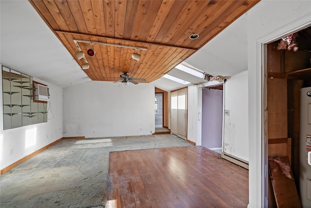 empty room featuring a wall unit AC, baseboard heating, baseboards, vaulted ceiling, and a ceiling fan