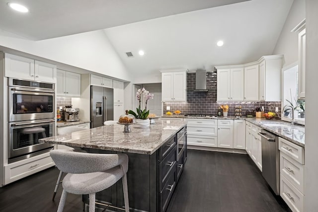 kitchen featuring white cabinets, stainless steel appliances, a breakfast bar, and a sink