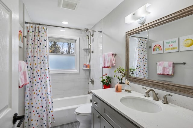 bathroom with toilet, vanity, shower / tub combo with curtain, and visible vents