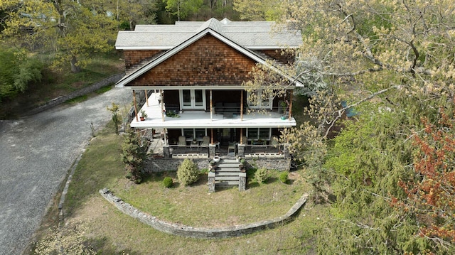 view of front of house featuring a porch, stairs, a balcony, and french doors