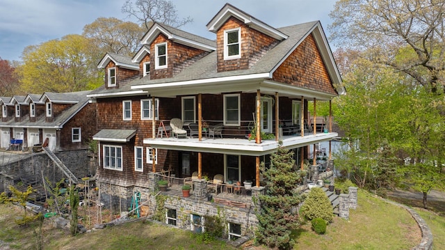 back of property featuring a shingled roof and a balcony