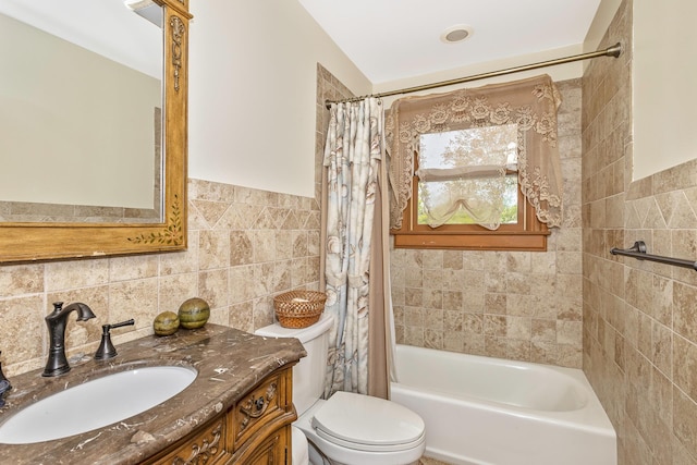 bathroom with vanity, shower / bathtub combination with curtain, toilet, and tile walls