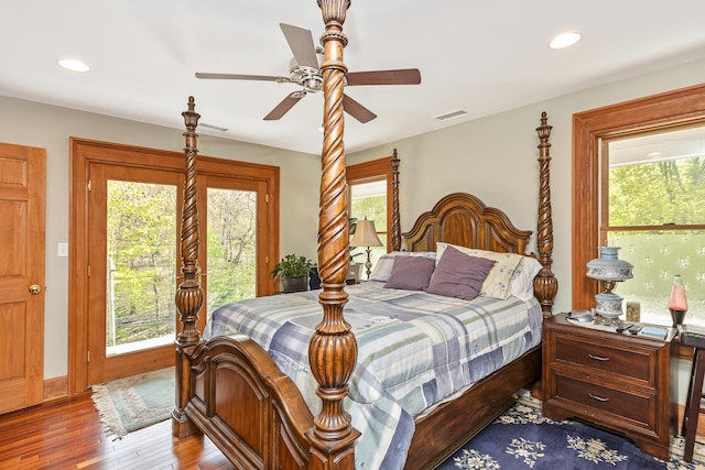 bedroom featuring multiple windows, hardwood / wood-style flooring, and visible vents