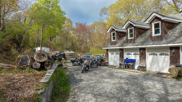 view of property exterior with roof with shingles and a garage