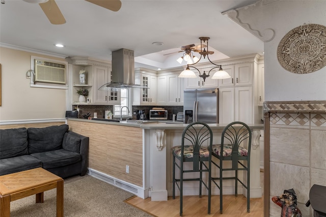 431 Grand Blvd, Brentwood, NY 11717 - kitchen with exhaust hood, a ceiling fan, a peninsula, stainless steel refrigerator with ice dispenser, and a breakfast bar area