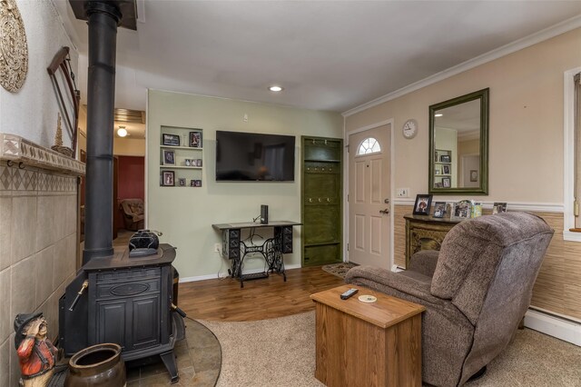 431 Grand Blvd, Brentwood, NY 11717 - living room with recessed lighting, wood finished floors, a wood stove, crown molding, and a baseboard radiator