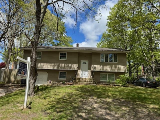 27 Hampton Ave, Mastic, NY 11950 - bi-level home with entry steps, an attached garage, and a front lawn