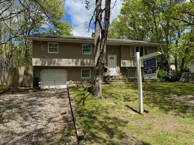 27 Hampton Ave, Mastic, NY 11950 - view of front facade featuring a garage and dirt driveway