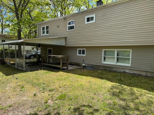 27 Hampton Ave, Mastic, NY 11950 - rear view of house featuring a lawn, a carport, and a chimney
