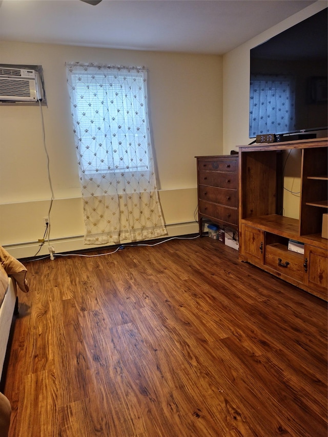 unfurnished bedroom featuring wood finished floors and an AC wall unit