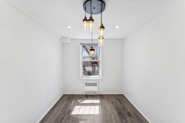 unfurnished dining area with baseboards, recessed lighting, radiator, and wood finished floors
