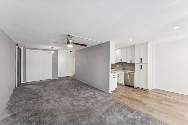 unfurnished living room with light wood-style floors, ceiling fan, a sink, and recessed lighting