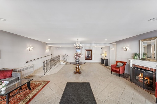 living area featuring an inviting chandelier, ornamental molding, a fireplace, recessed lighting, and light tile patterned flooring