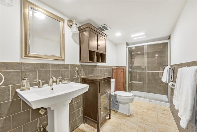 bathroom featuring tile walls, a shower stall, a wainscoted wall, toilet, and recessed lighting