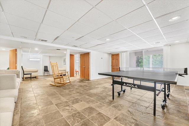 rec room with visible vents, recessed lighting, stone finish flooring, and a drop ceiling