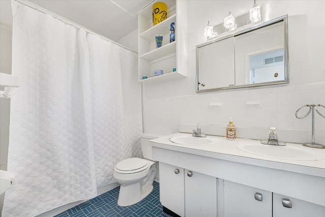 full bath with a sink, tile walls, tile patterned flooring, and toilet