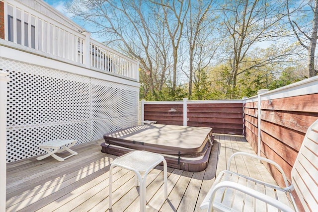 deck featuring fence and hot tub deck surround