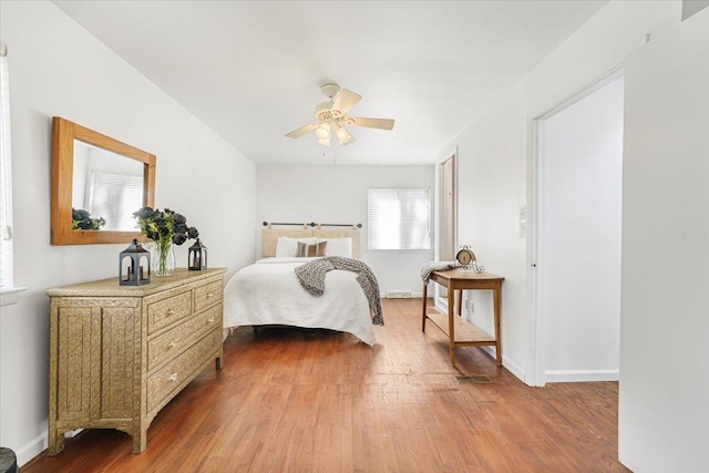 bedroom featuring a ceiling fan, baseboards, and wood finished floors