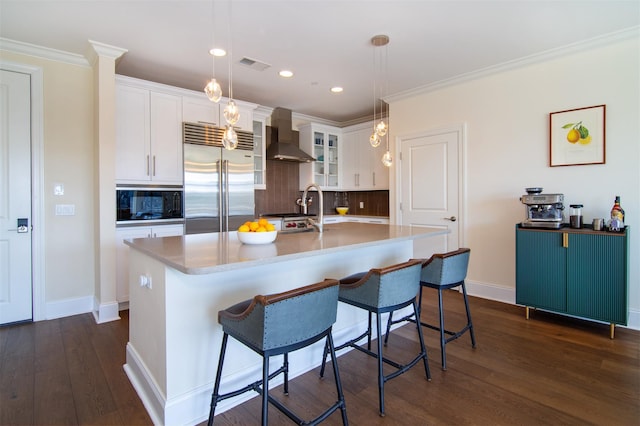 18 Rivers Edge Dr Unit 506, Tarrytown, NY 10591 - kitchen featuring built in appliances, wall chimney range hood, backsplash, a kitchen breakfast bar, and white cabinetry