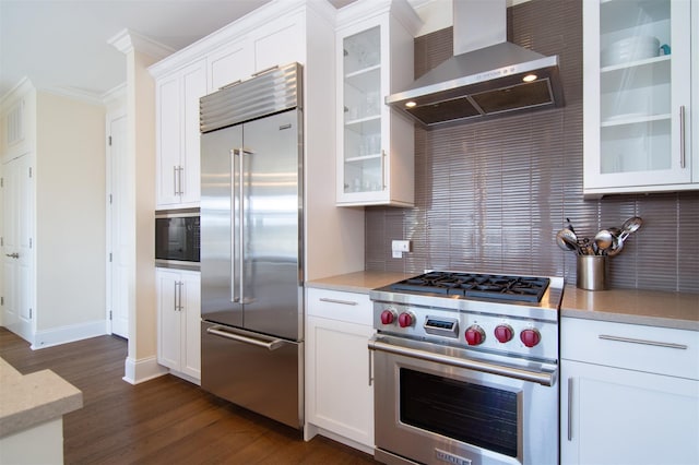 18 Rivers Edge Dr Unit 506, Tarrytown, NY 10591 - kitchen with built in appliances, wall chimney range hood, dark wood-type flooring, crown molding, and decorative backsplash