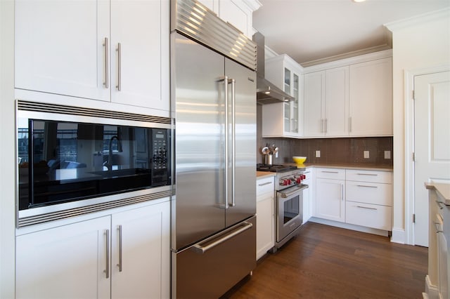 18 Rivers Edge Dr Unit 506, Tarrytown, NY 10591 - kitchen featuring built in appliances, wall chimney exhaust hood, white cabinets, backsplash, and dark wood-type flooring