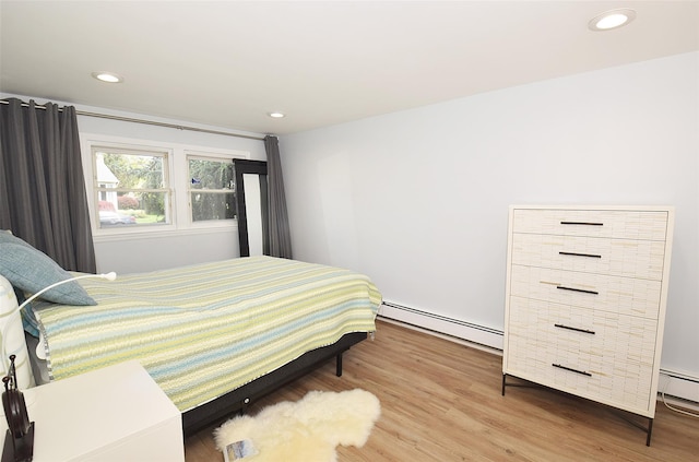 bedroom featuring baseboard heating, wood finished floors, and recessed lighting