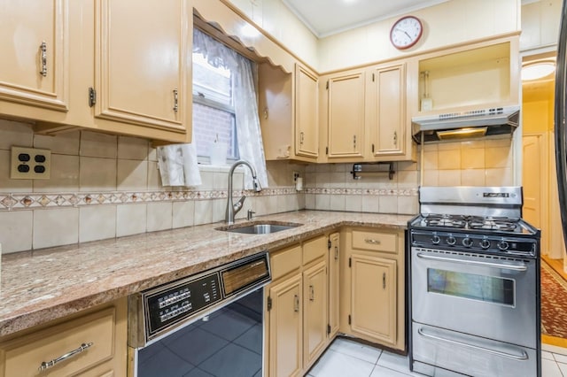 kitchen with black dishwasher, gas range, under cabinet range hood, a sink, and cream cabinets