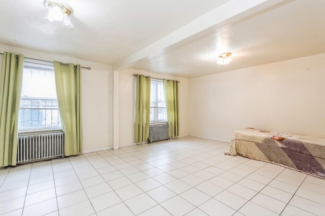 unfurnished bedroom with light tile patterned floors and radiator